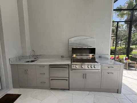 Beautiful American outdoor polymer cabinet kitchen with built in grill and drawer fridge. This clean polymer cabinet outdoor kitchen features a built in grill and double drawer outdoor fridge.