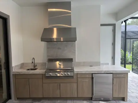 NatureKast cabinet outdoor kitchen with mitred edge countertops. Includes a built in Grill, outdoor fridge and vent hood. NatureKast outdoor kitchen with built in Grill, Fridge and vent hood.