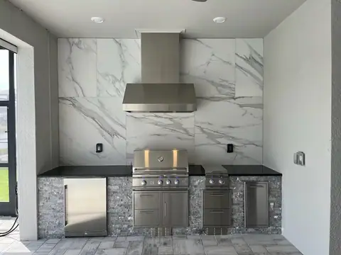 An outdoor kitchen with large format tile rear wall installed in Babcock Ranch, FL. An outdoor kitchen with large format tile rear wall installed in Babcock Ranch, FL.
