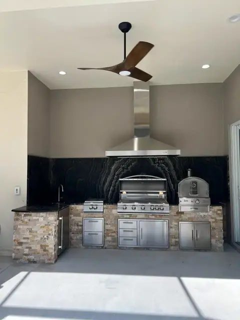 A custom Outdoor Kitchen with Exotic Granite in Bonita Springs, FL. A custom Outdoor Kitchen with Exotic Granite in Bonita Springs, FL with a grill, burner and pizza oven.