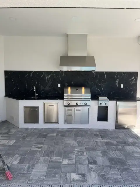 A custom outdoor kitchen with full width, full height backsplash installed in Naples FL. A custom outdoor kitchen with full width, full height backsplash installed in Naples FL.