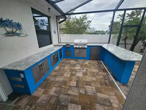 A custom concrete outdoor kitchen with bar, Punta Gorda, FL with grill, fridge and storage inserts. A custom concrete outdoor kitchen with bar, Punta Gorda, FL with grill, fridge and storage inserts.
