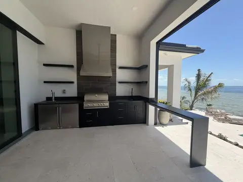 Custom outdoor kitchen with floating bar and shelves. Custom outdoor polymer kitchen with built in kegerator and fridge.