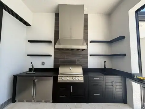 Custom polymer outdoor kitchen in black finish. Custom polymer outdoor kitchen in black finish, with Dekton countertops and built in Fridge and Kegerator.