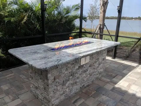 An Outdoor gas fireplace with granite top and stack stone in Naples, FL An outdoor propane gas fireplace with granite top and stack stone exterior in Naples, FL