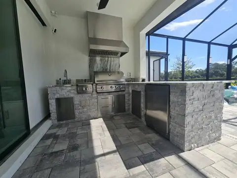 L shaped outdoor kitchen with stacked stone built in Naples FL. L shaped outdoor kitchen with stacked stone built in Naples FL.