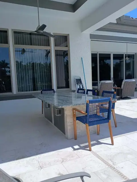 A large outdoor kitchen island with granite top and stainless storage inserts in Bonita Springs, FL. A large outdoor kitchen island with granite top and stainless storage inserts in Bonita Springs, FL.